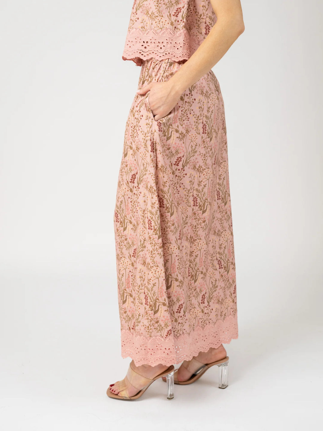 Side profile view of a woman wearing the Markey Skirt in Autumn Stems Rose, showing the A-line silhouette and tiered eyelet lace hem.
