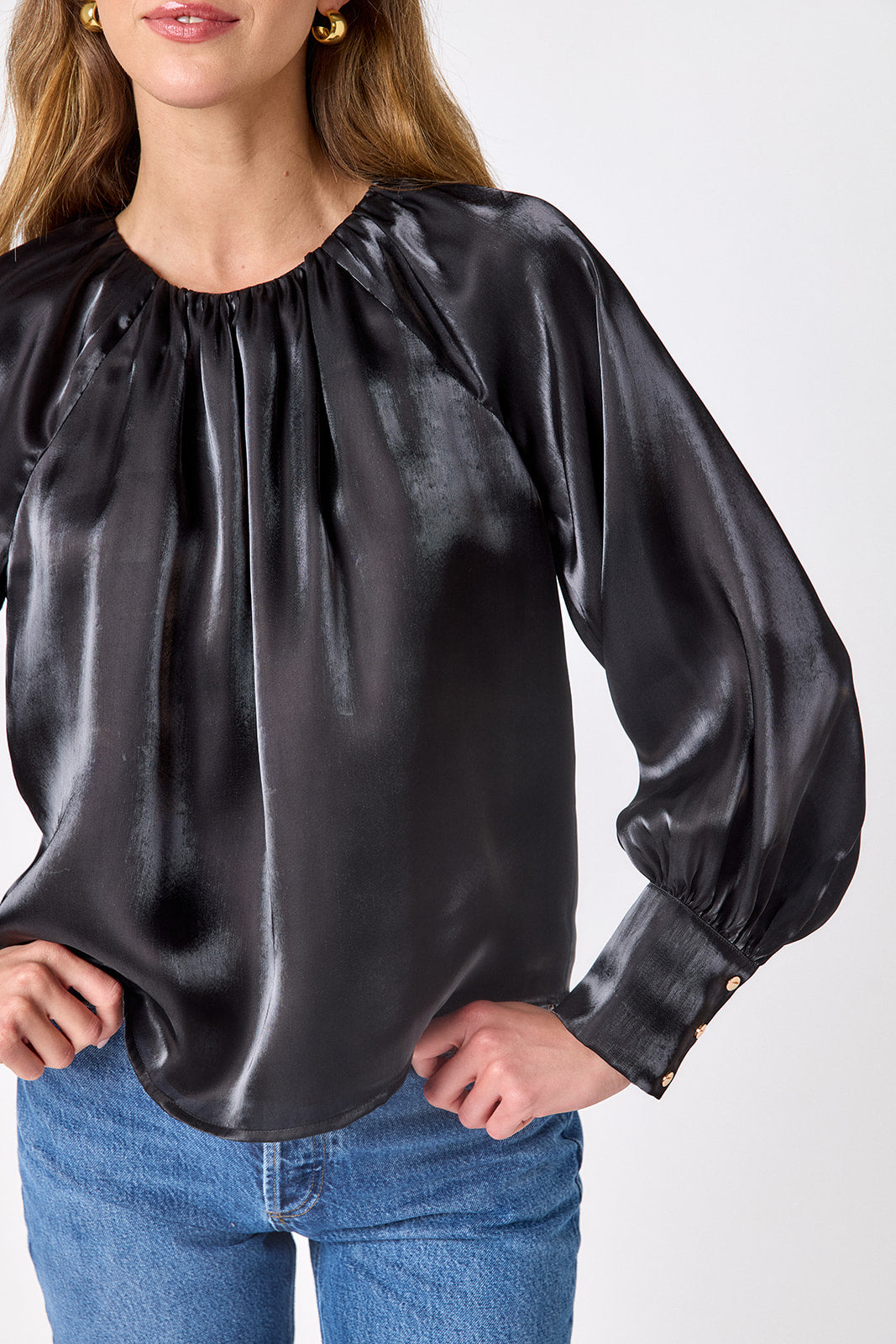Crosby Elizabeth Blouse in Black, back view on model showing gathered back neckline with button closure, full sleeves, and curved hem
