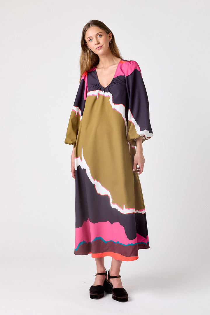 Crosby Ryker Dress in Portoro, front view on model showing gathered V-neckline, balloon sleeves, and abstract olive, aubergine, and pink landscape print