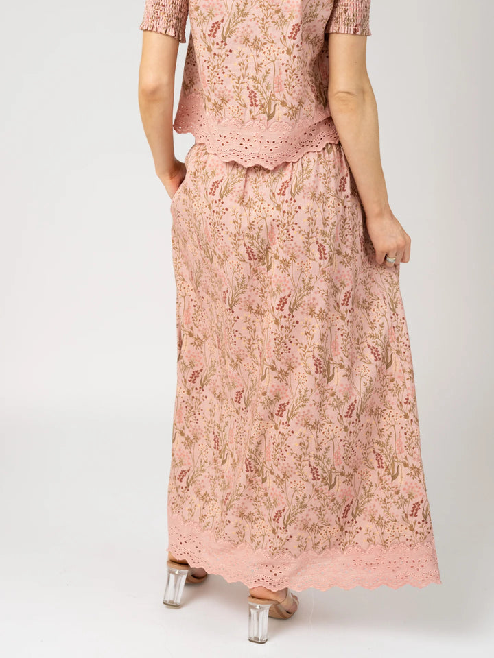 Back view of a woman wearing the Markey Skirt in Autumn Stems Rose with the coordinating Louisa Top, hand in pocket.