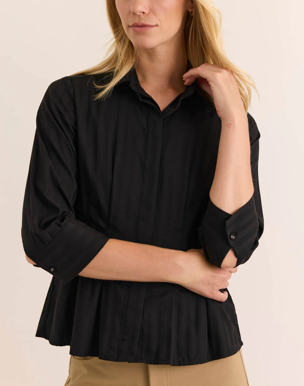 Front-facing view of the Hinson Wu 3/4 Sleeve Martina Top highlighting the fitted silhouette and pleated peplum hem, worn with camel trousers.