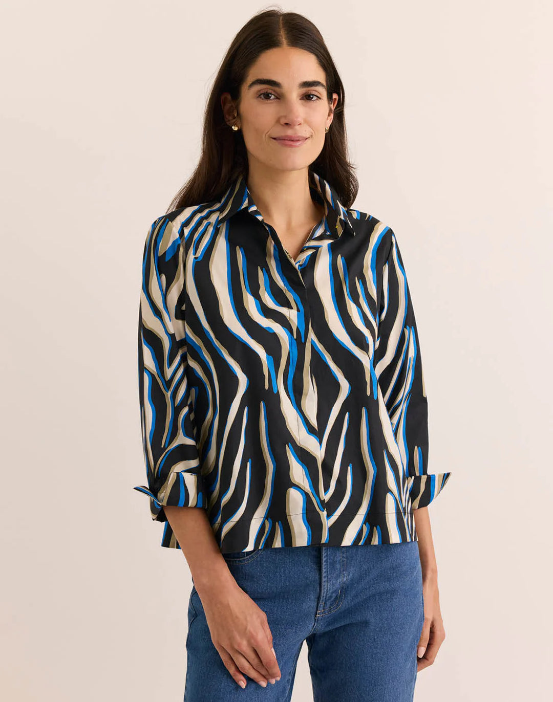 Hinson Wu 3/4 Sleeve Xena Top in abstract zebra print of black, cobalt blue, and sand, styled with a point collar and cuffed sleeves, worn with medium-wash denim against a neutral backdrop2