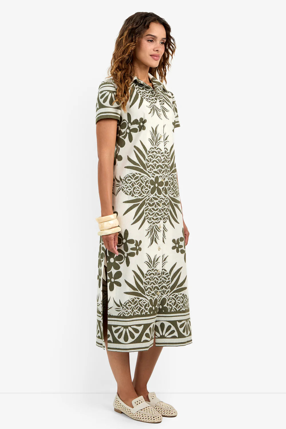 Side view of model wearing the Trina Turk Abba Midi Dress, highlighting the graphic hem border.