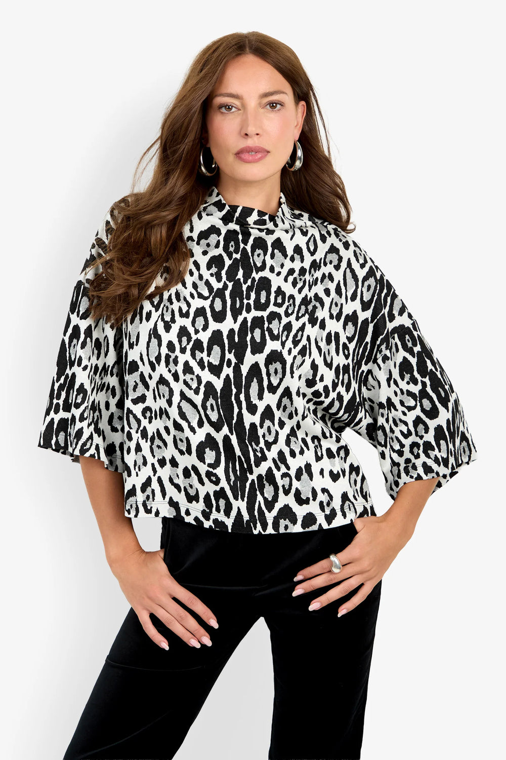 Close-up of the Trina Turk Sidony Top highlighting the black-and-white leopard jacquard, funnel neckline, and wide dolman sleeve shape.