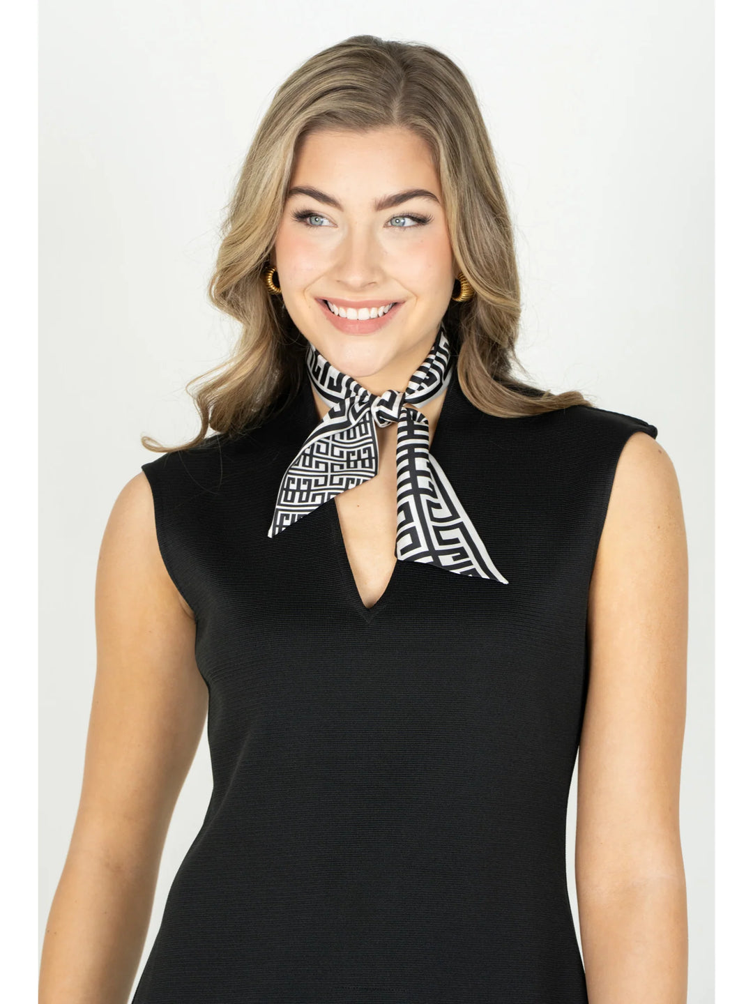 Emily McCarthy Silk Scarfette in Black Greek Key — front on-model, tied at the neck over a black sleeveless top, showing reversible pattern scale