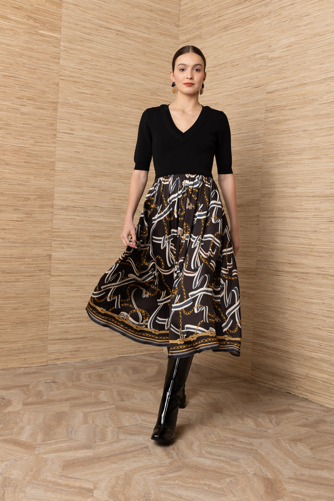 Hale Bob Landon Pleated Midi Dress in black with chain and ribbon print skirt — front view showing knit bodice and gathered skirt in motion