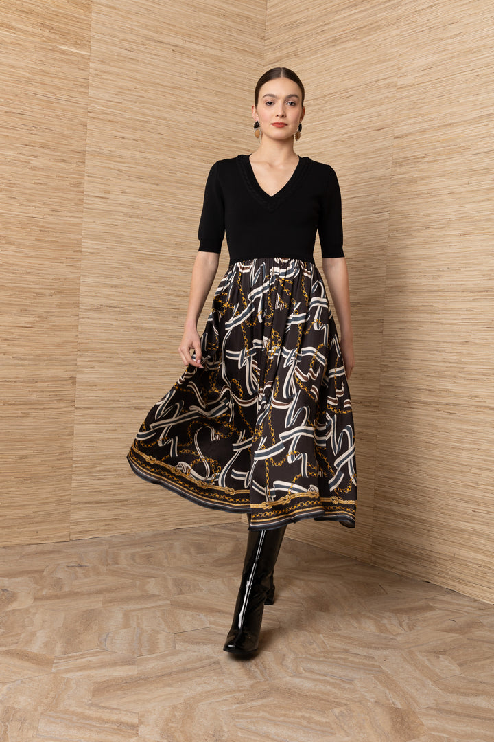 Hale Bob Landon Pleated Midi Dress in black with chain and ribbon print skirt — front view showing knit bodice and gathered skirt in motion