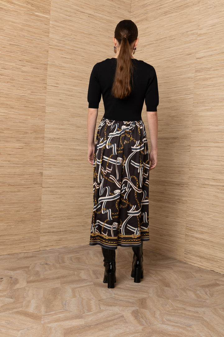 Hale Bob Landon Pleated Midi Dress in black with chain and ribbon print skirt — back view showing bodice fit and skirt fullness