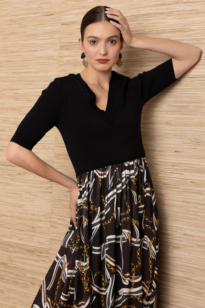 Hale Bob Landon Pleated Midi Dress in black with chain and ribbon print skirt — close-up front view showing neckline and sleeve detail