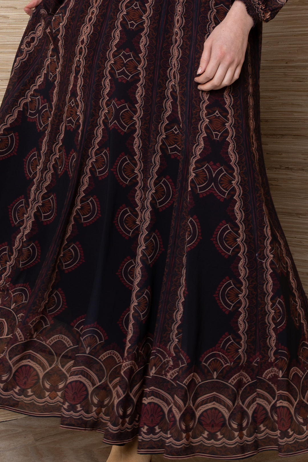 Hale Bob Iselda V Neck Maxi in Plum Multi, close-up of the skirt showing vertical lacework stripes, fan motifs, and ornate printed border at the hem.