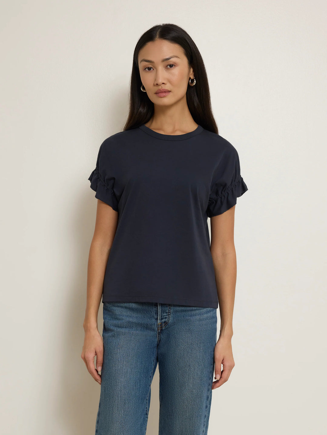 Front view of model wearing the Nation Los Angeles Arline Short Sleeve Top in Night Sky with denim.