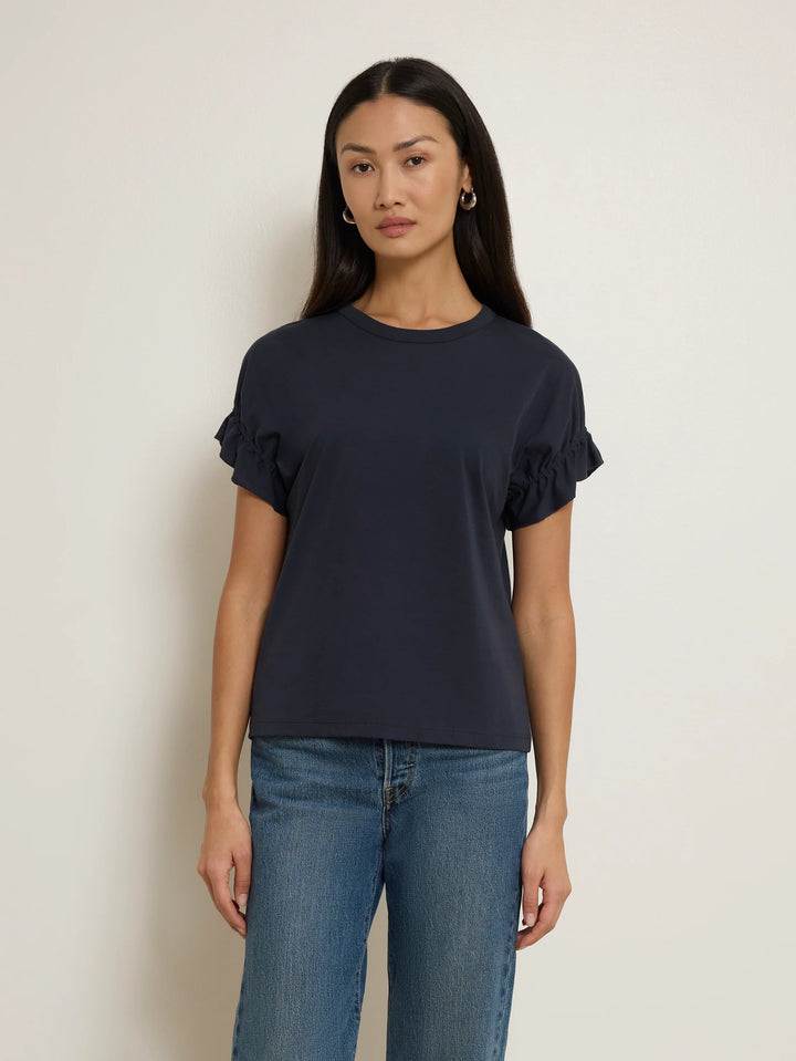 Front view of model wearing the Nation Los Angeles Arline Short Sleeve Top in Night Sky with denim.