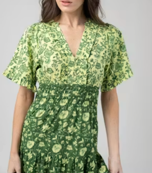 Close crop of the Beau & Ro Anya Dress showing the V-neckline, ruffled trim, and smocked waist detail in Jaipur Green print.