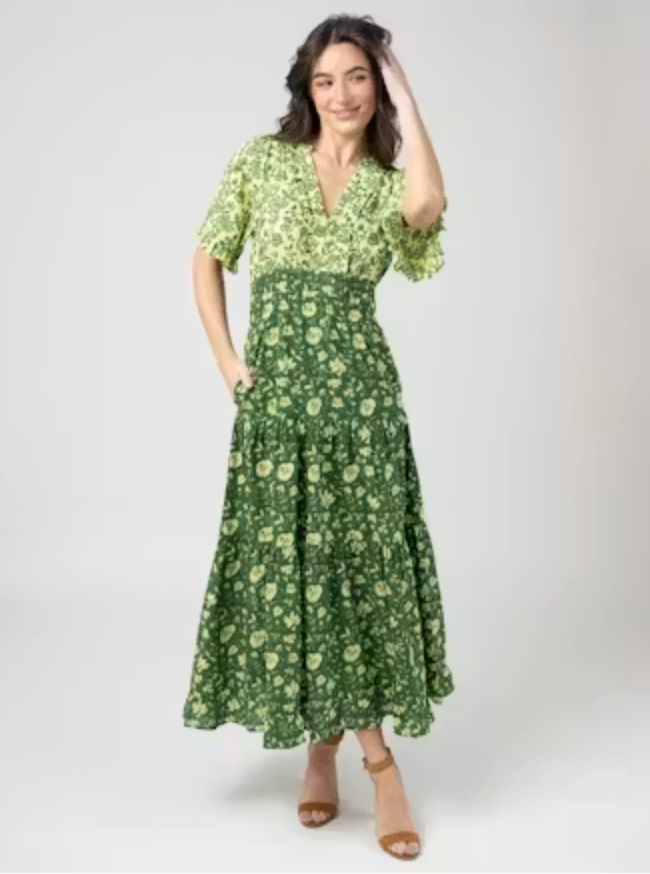 Alternate front-facing view of the Beau &amp; Ro Anya Dress in Jaipur Green two-tone floral, highlighting the smocked waist and side pockets, worn with brown sandals.