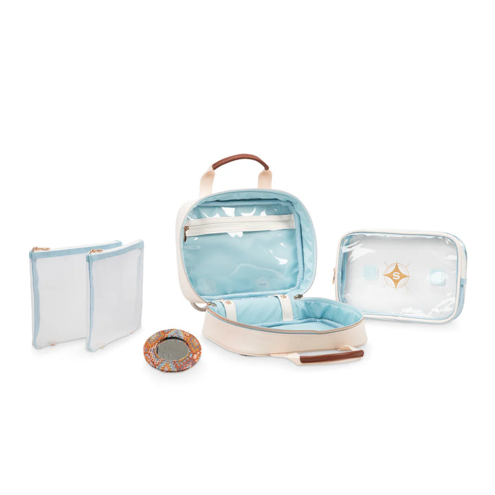 Interior detail view: Stephanie Johnson ML Traveler shown open and empty, highlighting pale blue lining, clear zip pocket, removable clear zip pouch, lift-out clear-topped tray, and round mirror compact in kilim print.