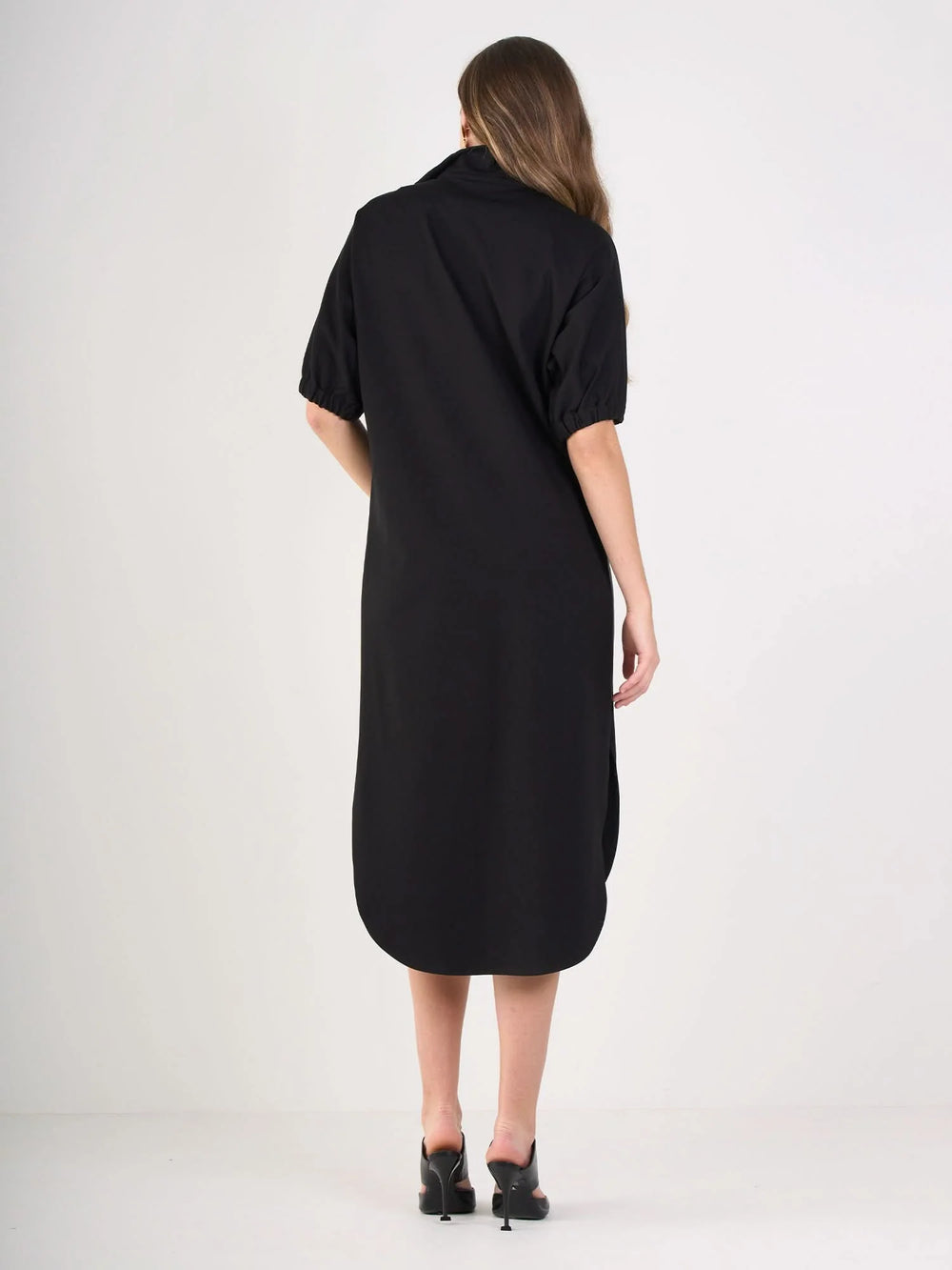 Back of Black ponte caftan with vegan leather tuxedo stripe detail, optional stand collar, and curved tail hem by Emily McCarthy.
