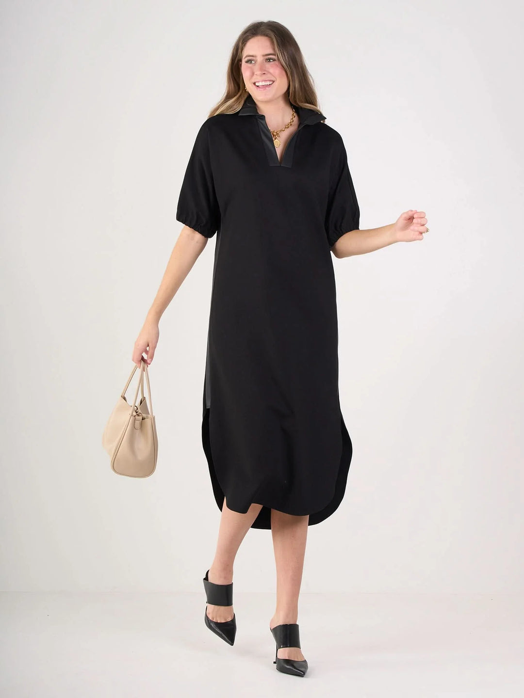 Black ponte caftan with vegan leather tuxedo stripe detail, optional stand collar, and curved tail hem by Emily McCarthy.