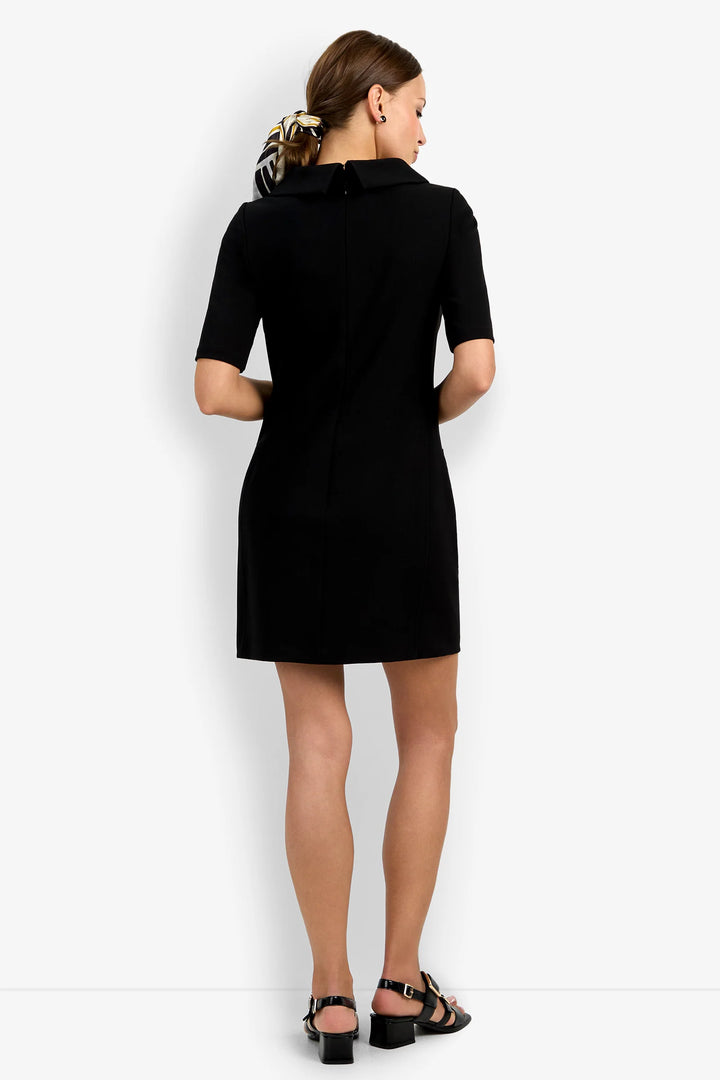 Back view of the Trina Turk Maleko Dress in black showing the folded neckline, short sleeves, shaping seams, and center-back zipper.