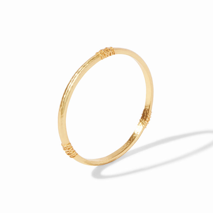 Julie Vos Catalina Bangle in 24K gold plate, shown on wrist — slim hammered band with bead-in-diamond detail.