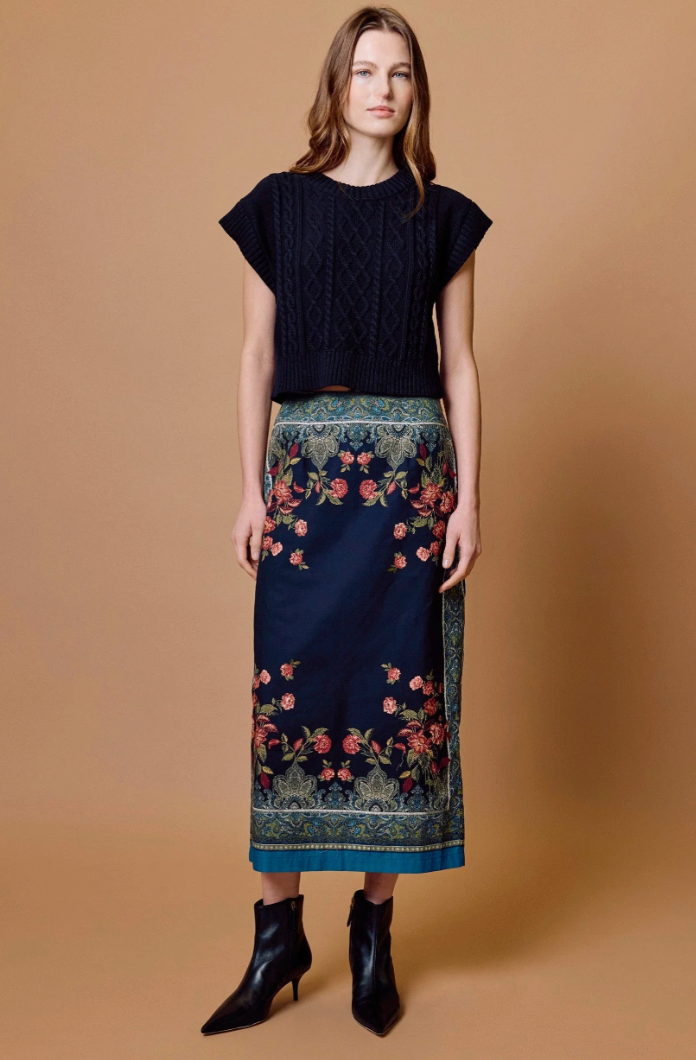 Cleobella Milena Midi Skirt in Eglantine Print, front view, model wearing navy floral-print midi skirt with cropped black knit top and ankle boots.