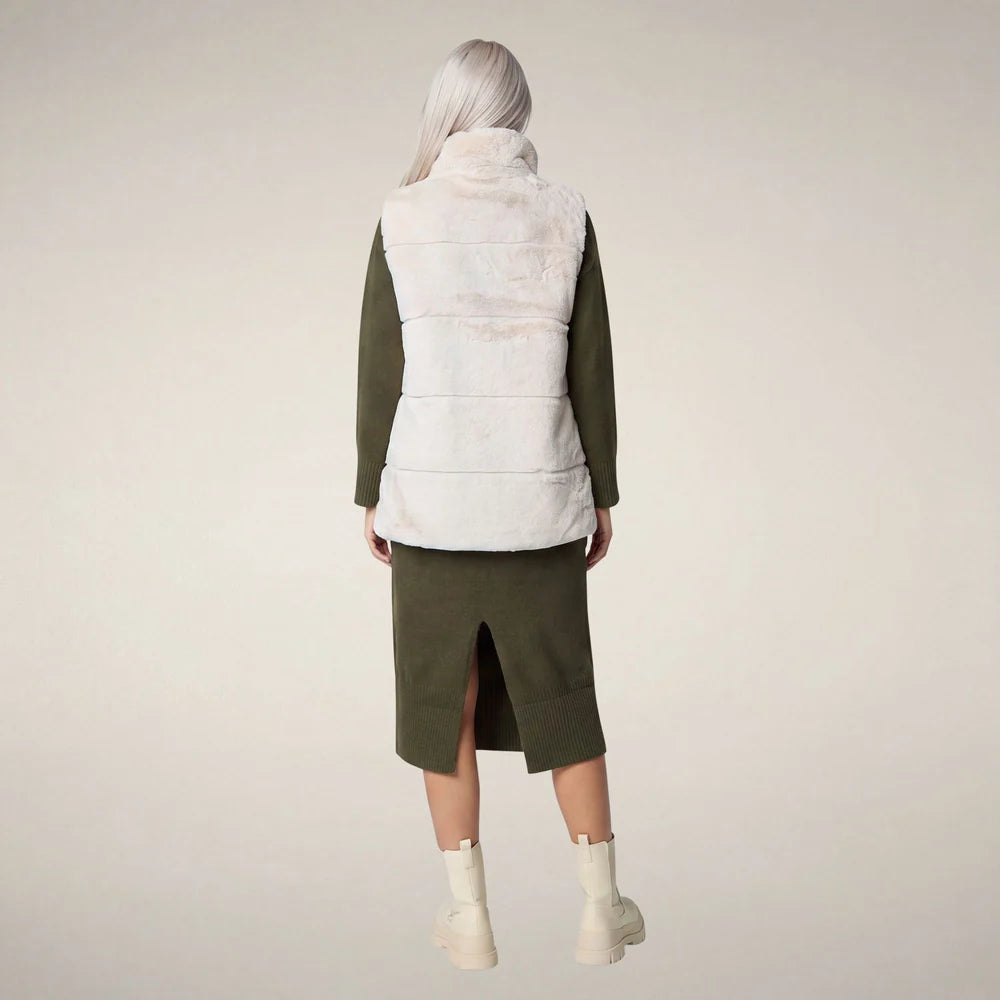 Back view of the Nives vest laid flat, showing the plush faux fur side in shore beige.