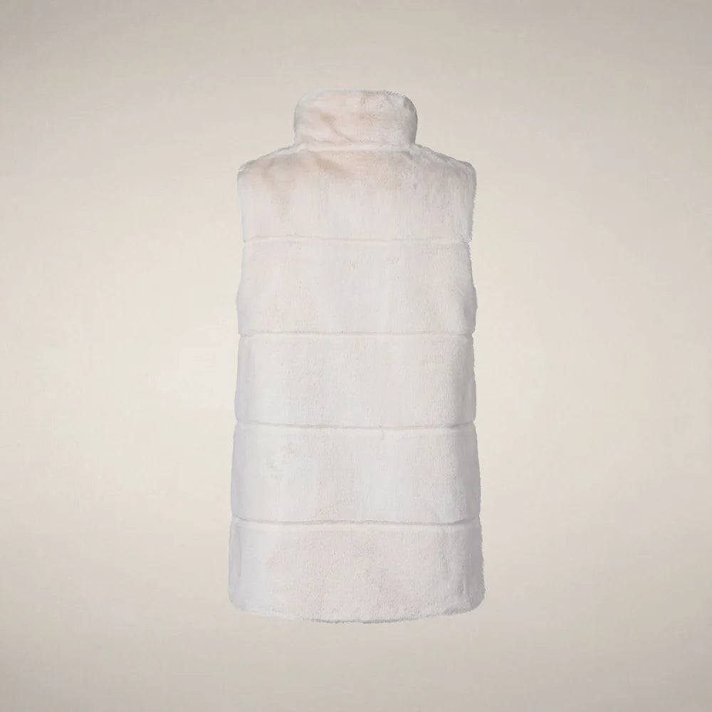 Back view of a woman wearing the Nives vest, showing the fit through the shoulders and length over the knit dress.