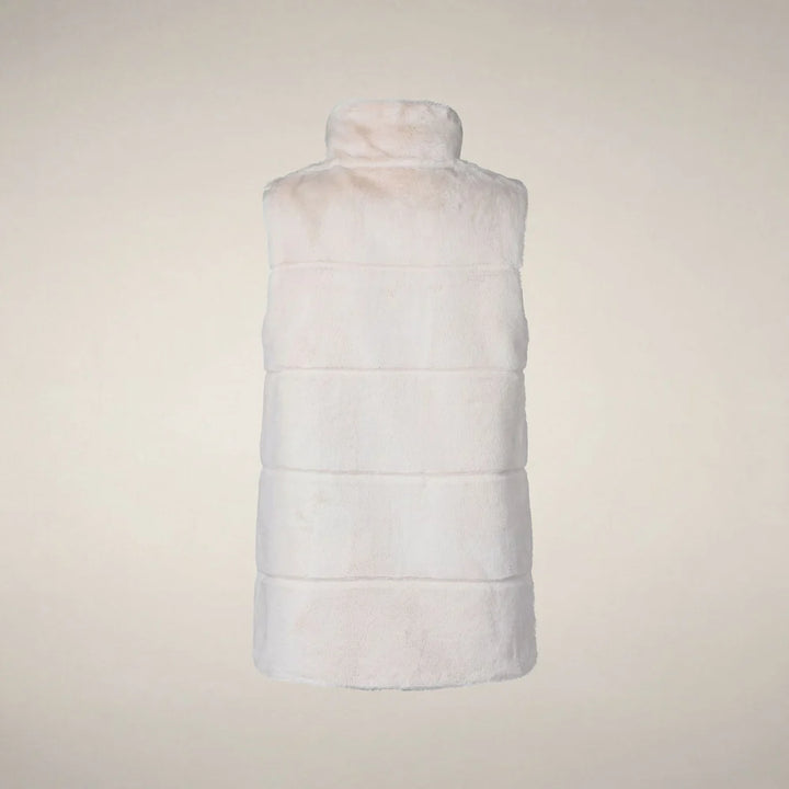 Back view of a woman wearing the Nives vest, showing the fit through the shoulders and length over the knit dress.