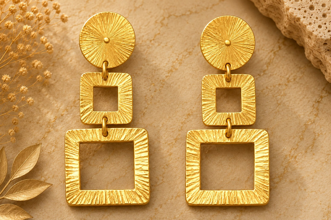 DAVET Gold Geometric Earrings by Ximena Castillo, three-tier textured gold-plated bronze drop earrings on natural stone surface