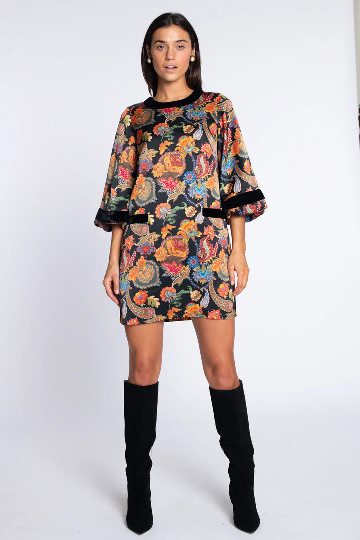 Front view of the Elizabeth James London Short Dress in paisley featuring a round neckline, black trim, faux front pockets, and softly flared three-quarter sleeves.