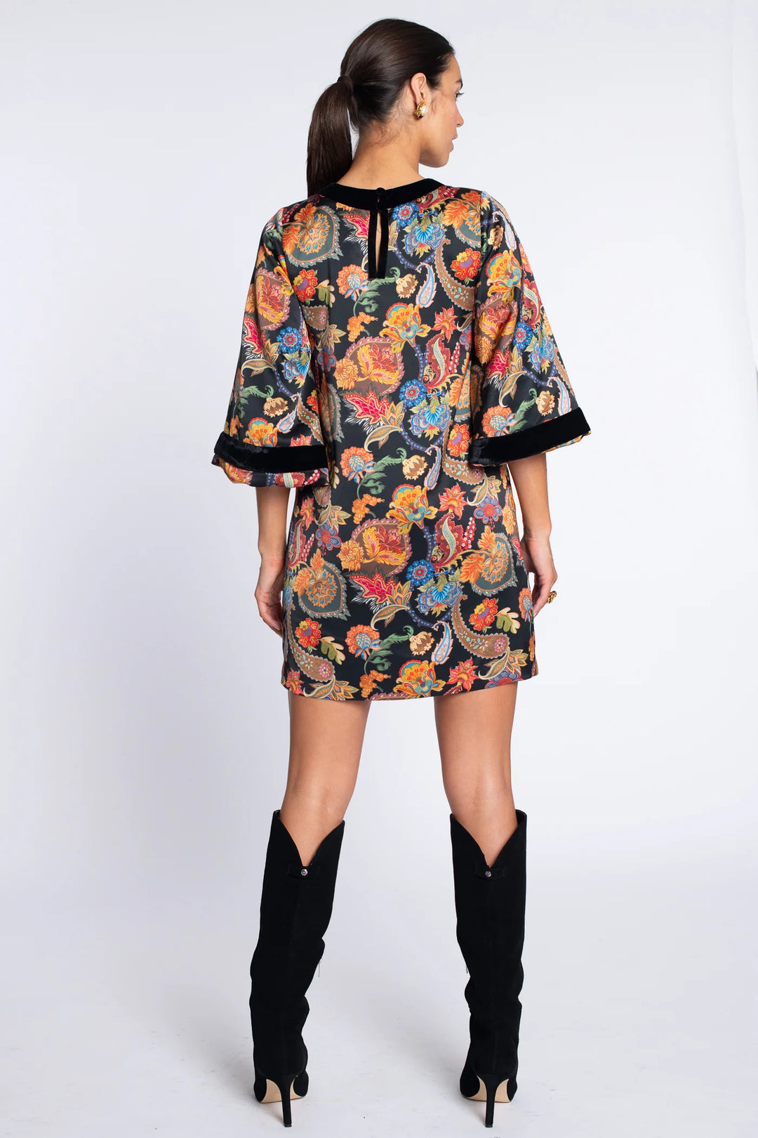Back view of the Elizabeth James London Short Dress in paisley showing the shift silhouette, black-trimmed neckline, balloon sleeves, and back button closure.