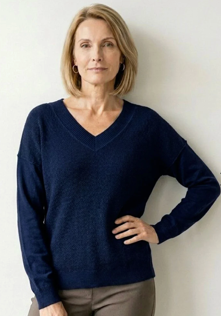 Elliott Lauren V-Neck Waffle Body Sweater in Indigo, front view, model wearing navy waffle-knit V-neck sweater with brown trousers.