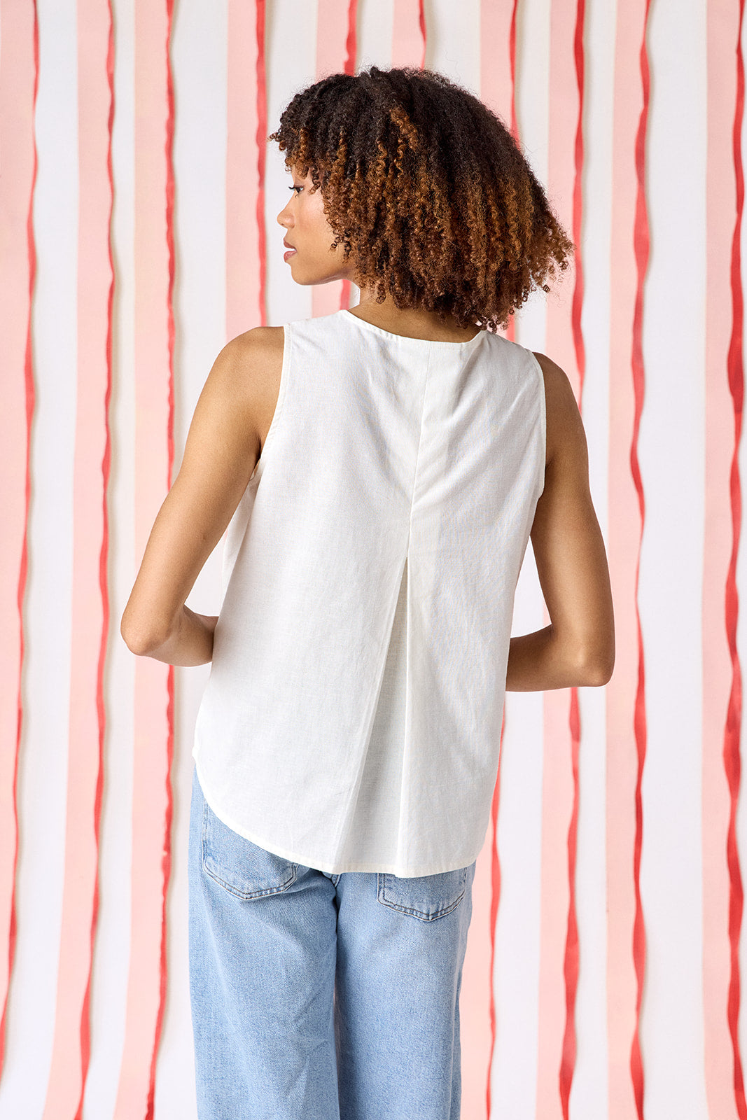 Back view of Crosby Elly Embroidered Tank Top in ivory showing center pleat detail, clean unembellished back, and rounded shirttail hem with relaxed boxy silhouette.