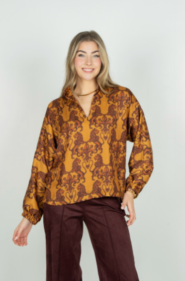 Emily McCarthy Long Sleeve Poppy Leone – front view on model, smiling, styled with burgundy wide-leg pants