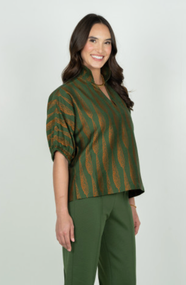 Emily McCarthy Poppy Tuscan Villa – side/front angle on model, smiling, styled with green trousers