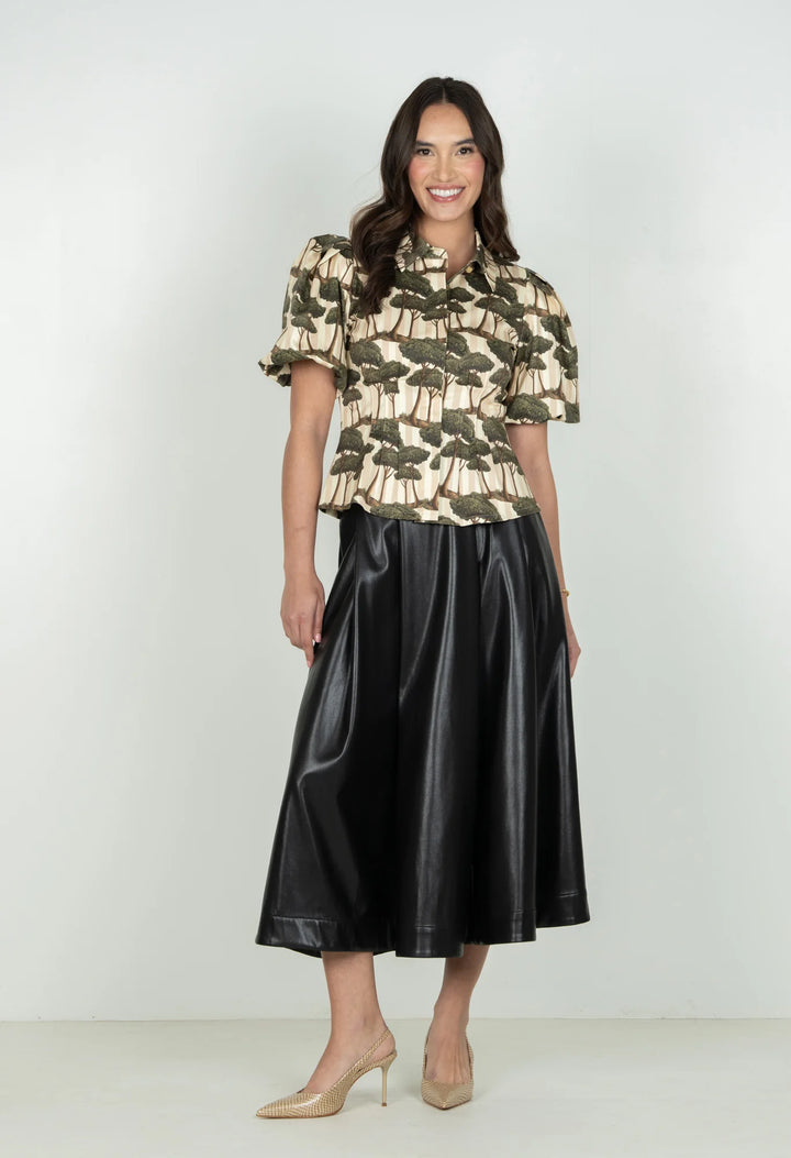 Emily McCarthy Britt Umbrella Pine Top — full front view styled with black faux leather A-line skirt