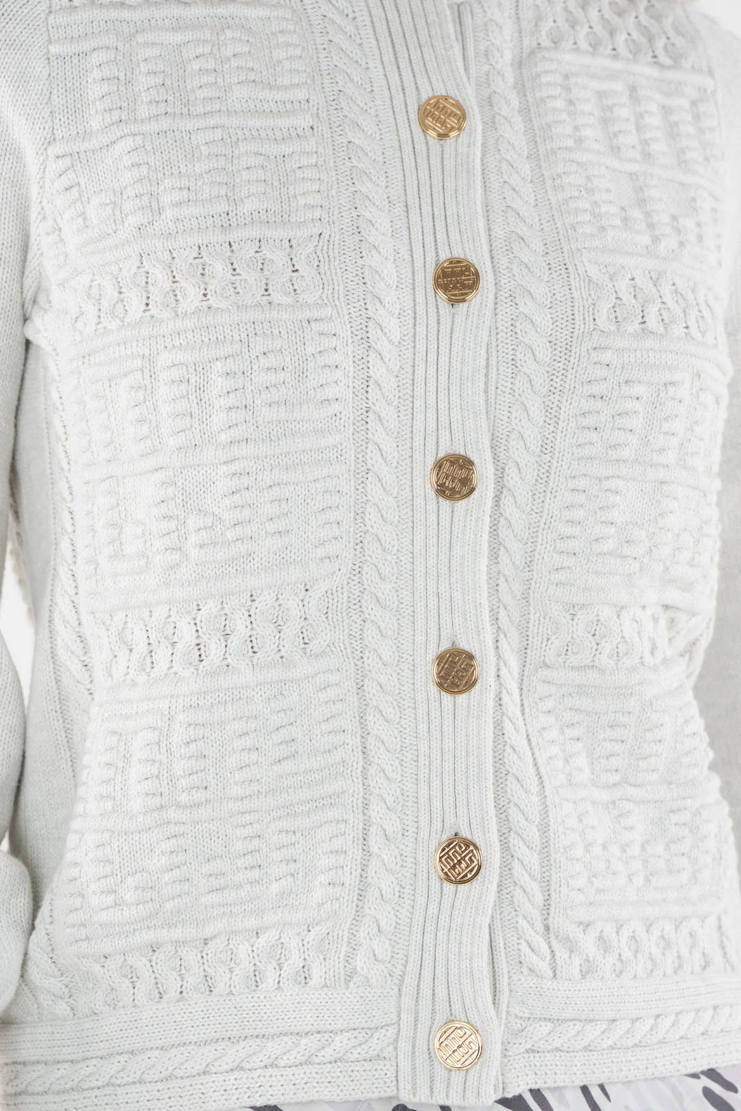 Emily McCarthy Chloe Cardigan in Carrara — detail view of gold logo buttons and knit pattern