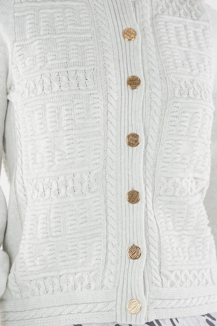 Emily McCarthy Chloe Cardigan in Carrara — detail view of gold logo buttons and knit pattern