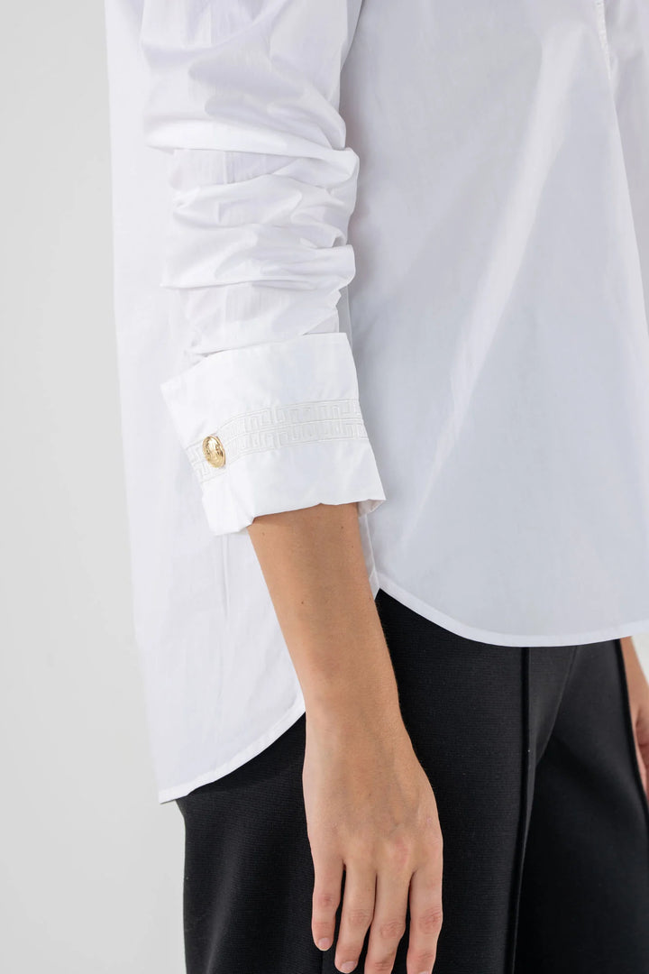 Emily McCarthy Classic Oxford Top in White — detail close-up of ruched cuff, embroidered trim, and gold button