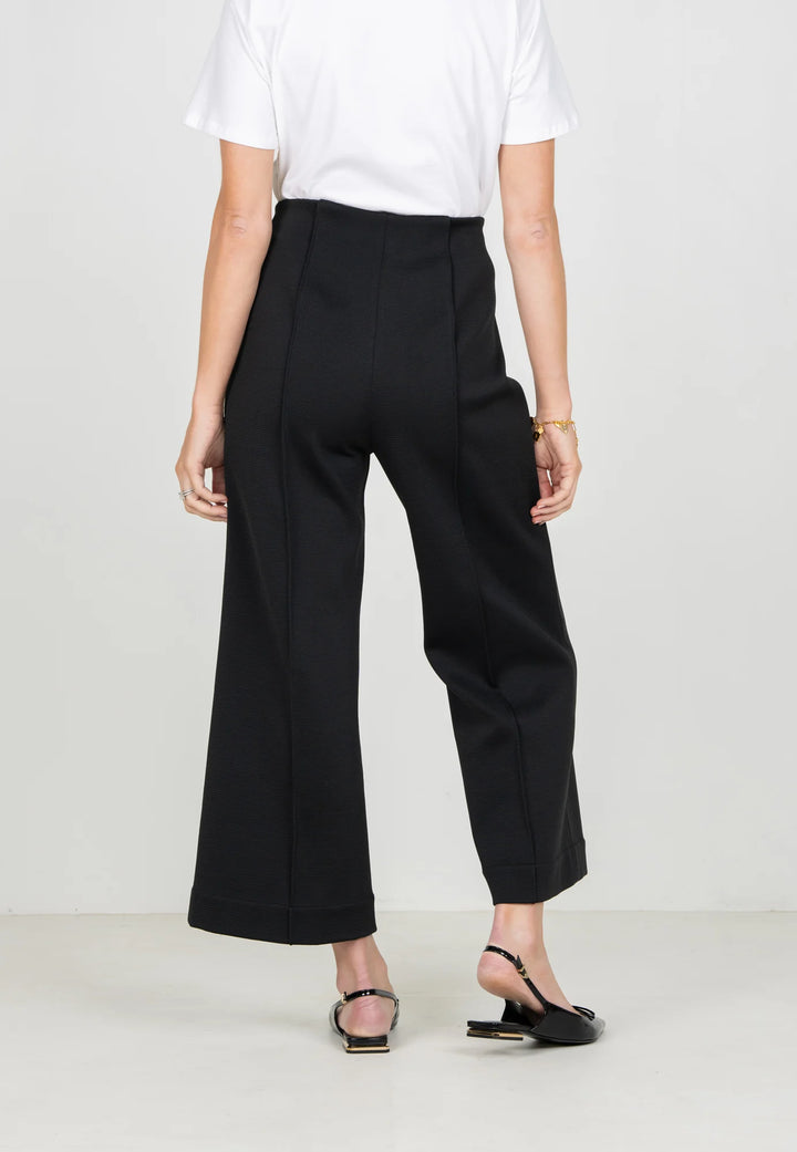 Emily McCarthy Cropped Piper Pant in Black — back detail on-model, showing pin-tuck seam and leg line