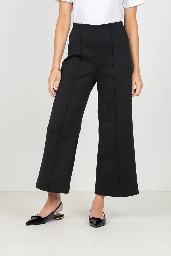 Emily McCarthy Cropped Piper Pant in Black — front detail on-model, showing pin-tuck seams and cropped hem