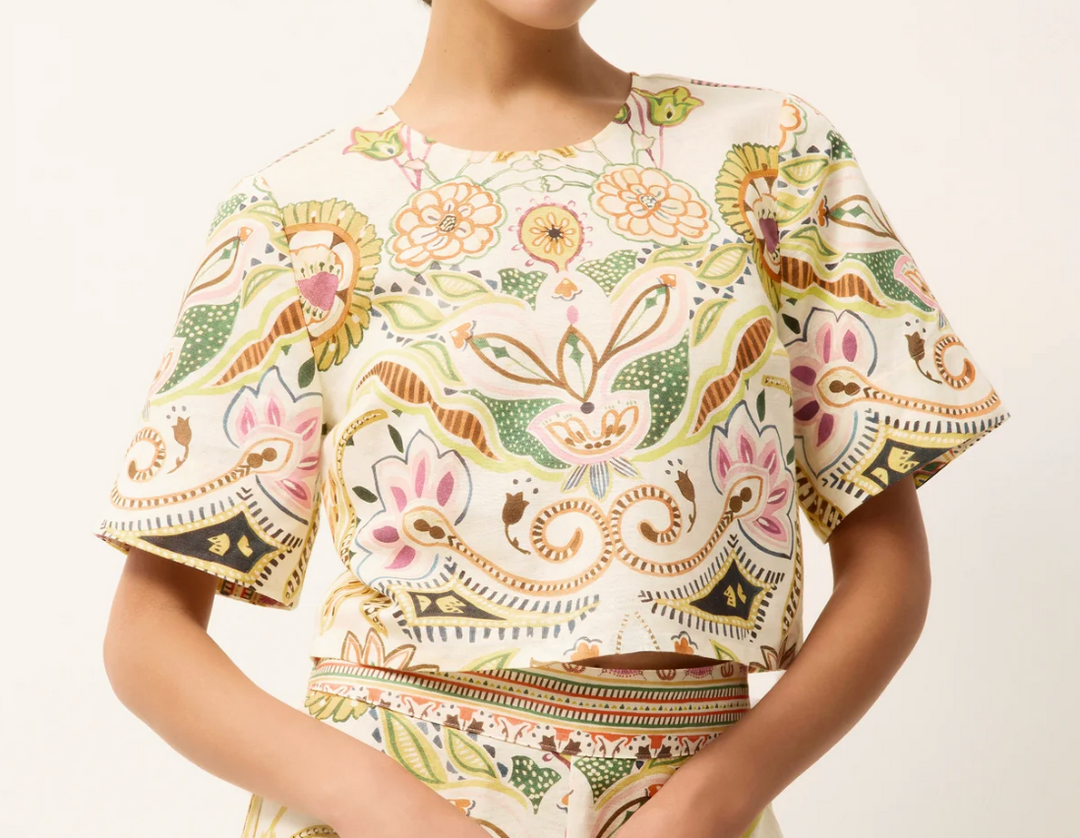 Woman wearing a floral blouse with a neutral background