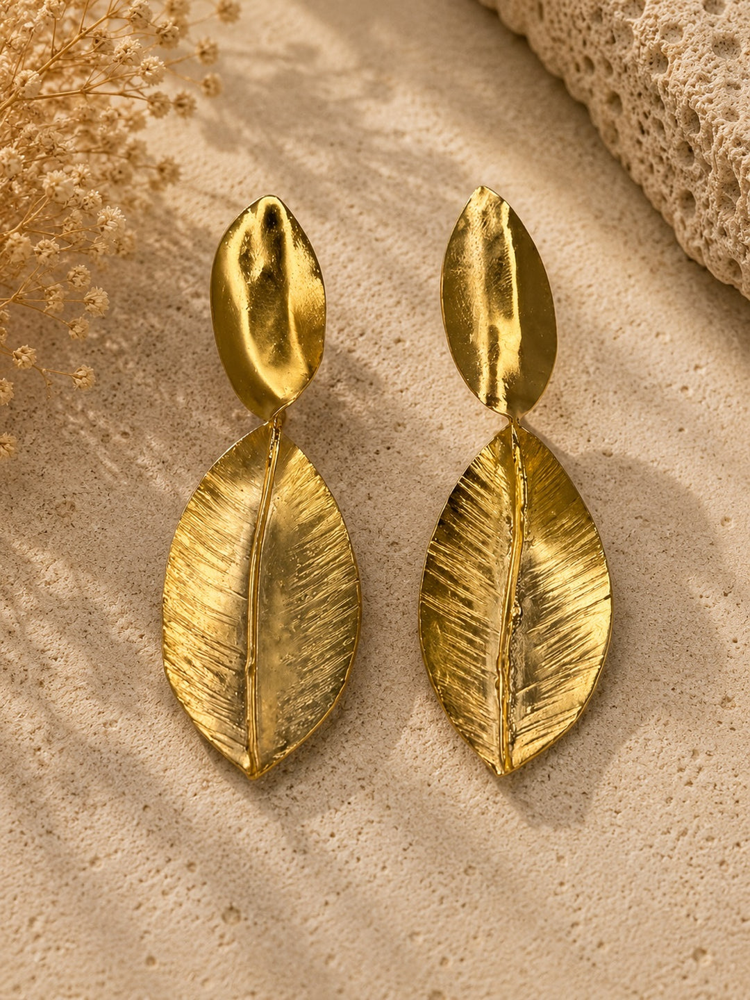 Detail close-up — GANA earrings showing hammered texture and incised vein detailing on lower leaf, gold-plated bronze finish