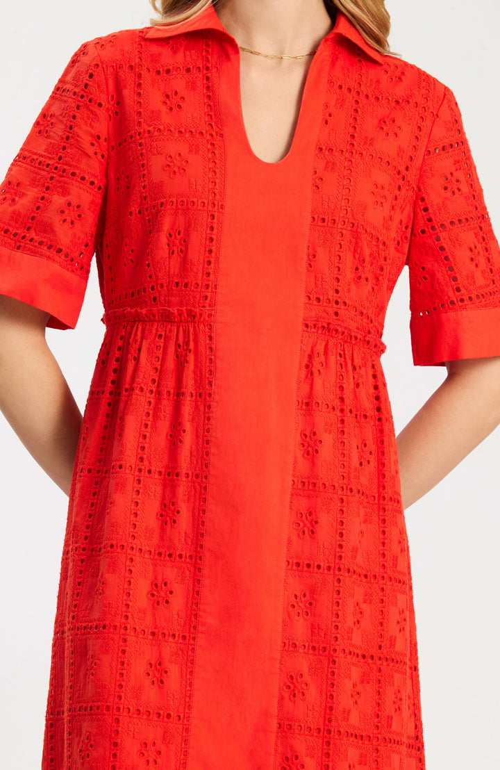 Model wearing Tyler Boe Lane Eyelet Maxi Dress in grenadine, full-length front view, styled with tan block-heel sandals and floral earrings, on white background. - closeup