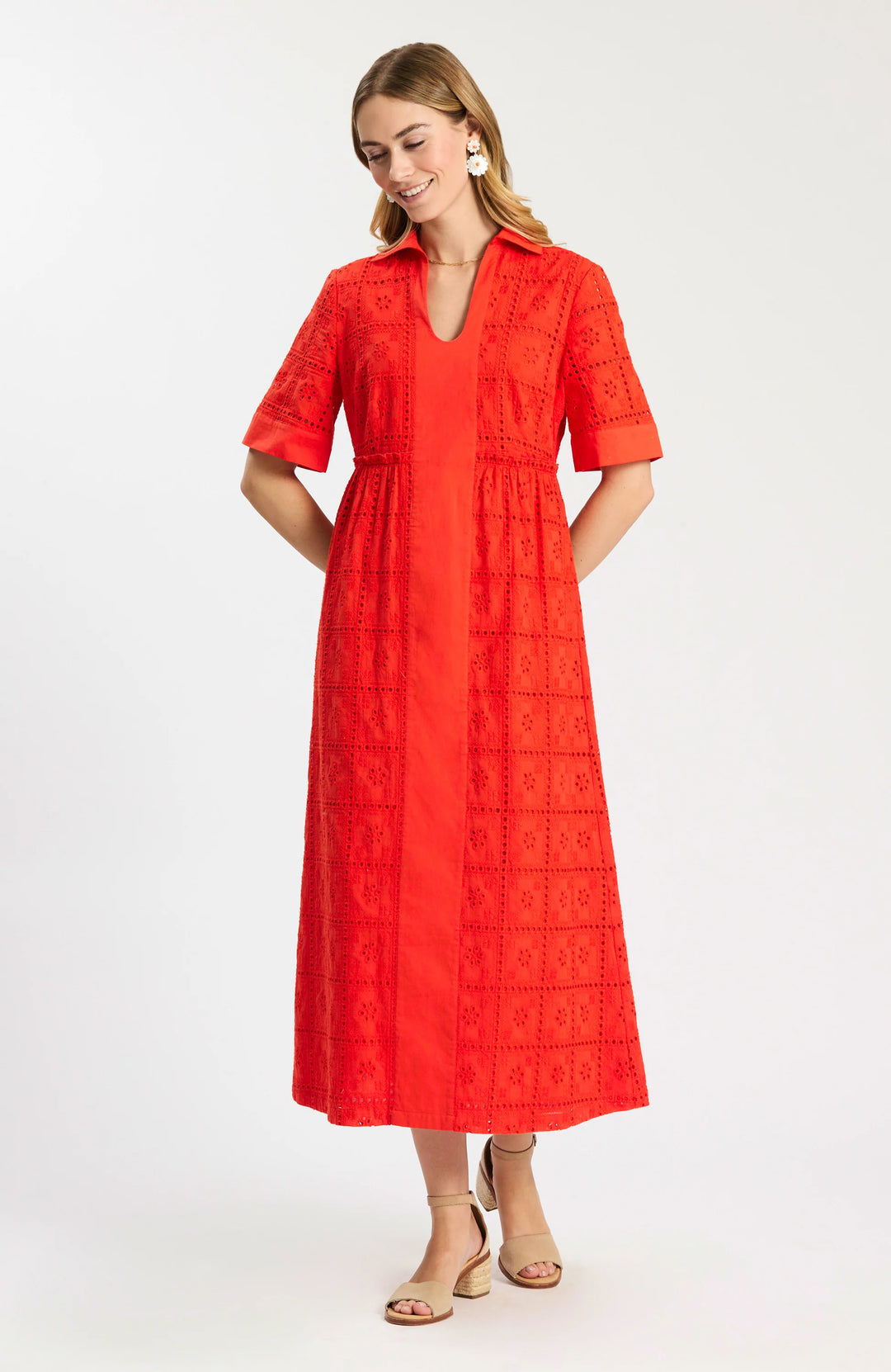 Model wearing Tyler Boe Lane Eyelet Maxi Dress in grenadine, full-length front view, styled with tan block-heel sandals and floral earrings, on white background.
