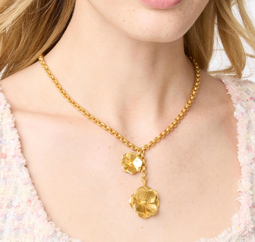 Julie Vos Bloom Lariat Necklace, on-model close-up worn at the neckline, showing flower drop detail against skin and knit fabric.