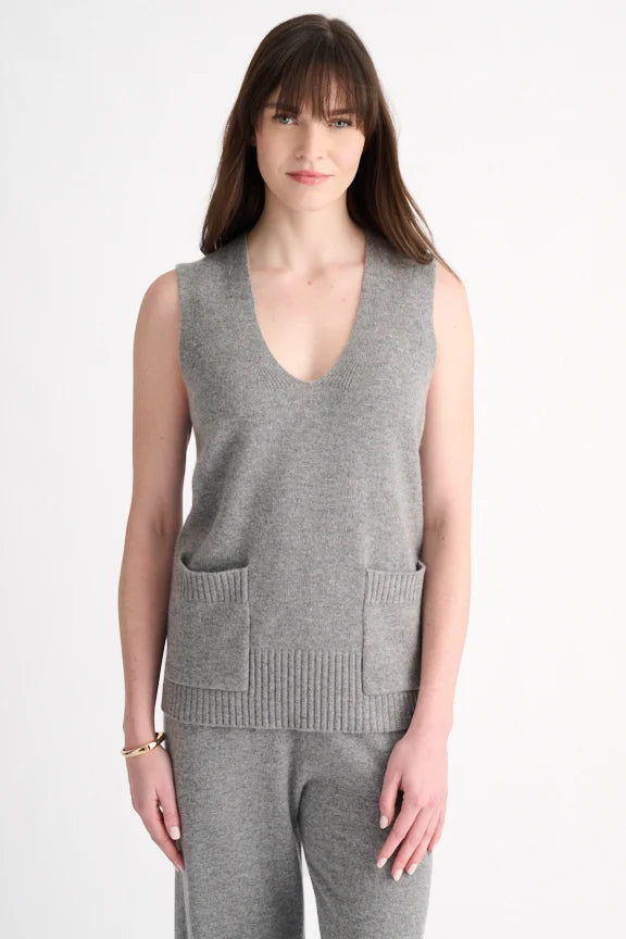 Woman wearing a granite grey cashmere V-neck vest with ribbed patch pockets over matching cashmere pants.