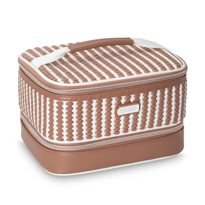 Front/angled view: Stephanie Johnson Jenny Train Case in Marbella colorway, showing woven caramel-and-white leather panel at top tier, solid tan lower tier, white edge piping, and leather-wrapped top handle.