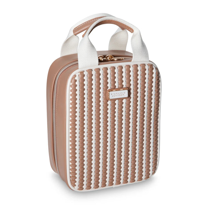 Front/angled view: Stephanie Johnson Sasha Travel Bag in Marbella colorway, showing upright rectangular silhouette with woven caramel-and-white leather panel, white edge piping, canvas-and-leather top handle, and rose gold zipper pull.