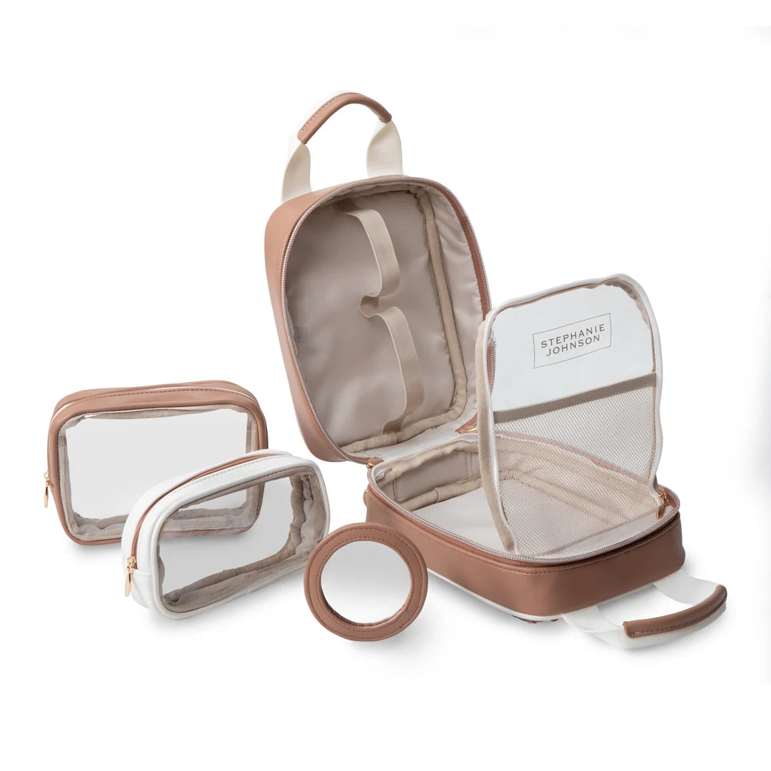 Flat lay with components: Stephanie Johnson Sasha Travel Bag open beside its two coordinating pouches (one clear, one solid with clear front) and round mirror compact, showing the full travel organization set.