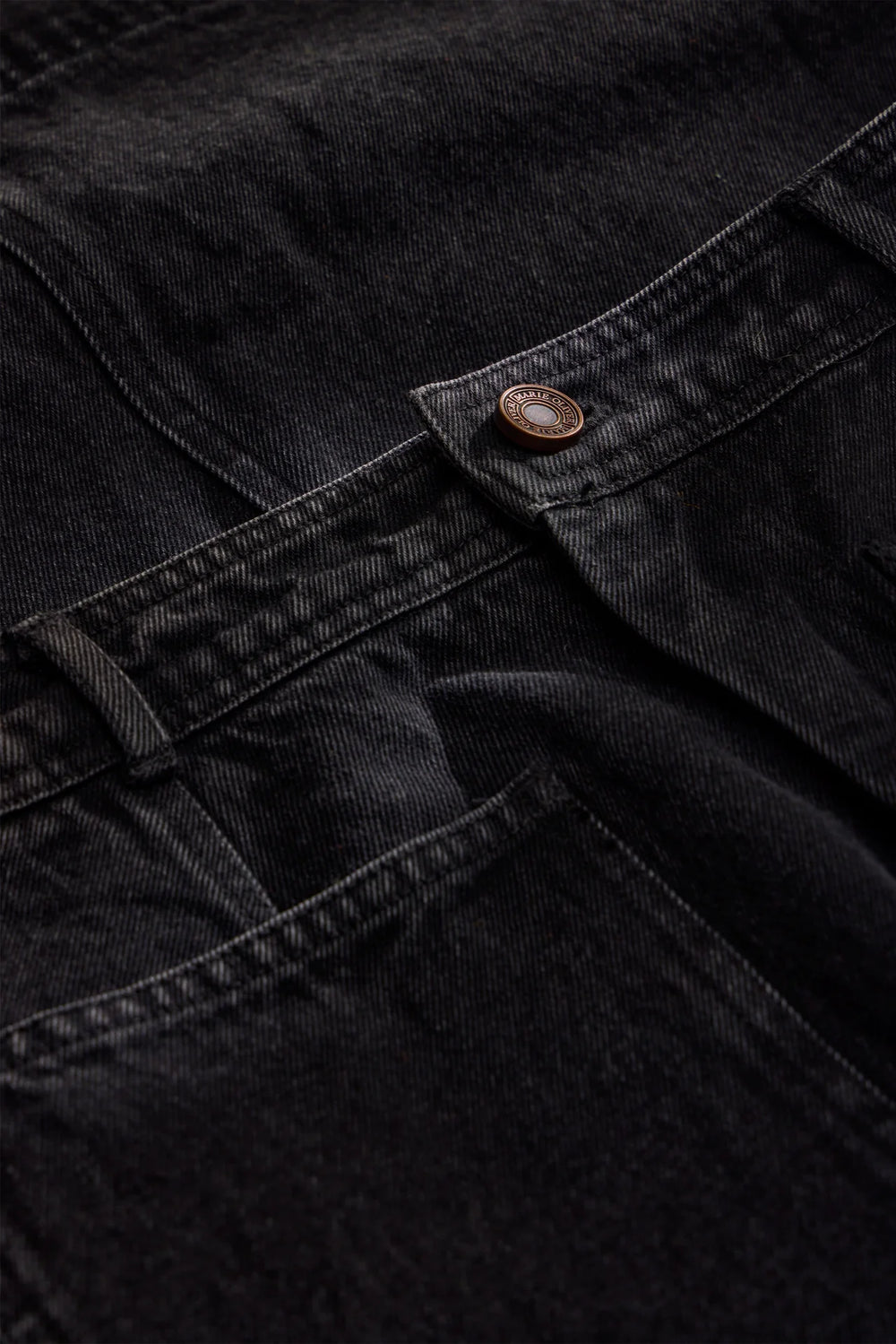 Marie Oliver Leighton Denim Skirt in Pavement, close-up detail of washed charcoal twill denim, belt loop, and copper-tone Marie Oliver engraved shank button